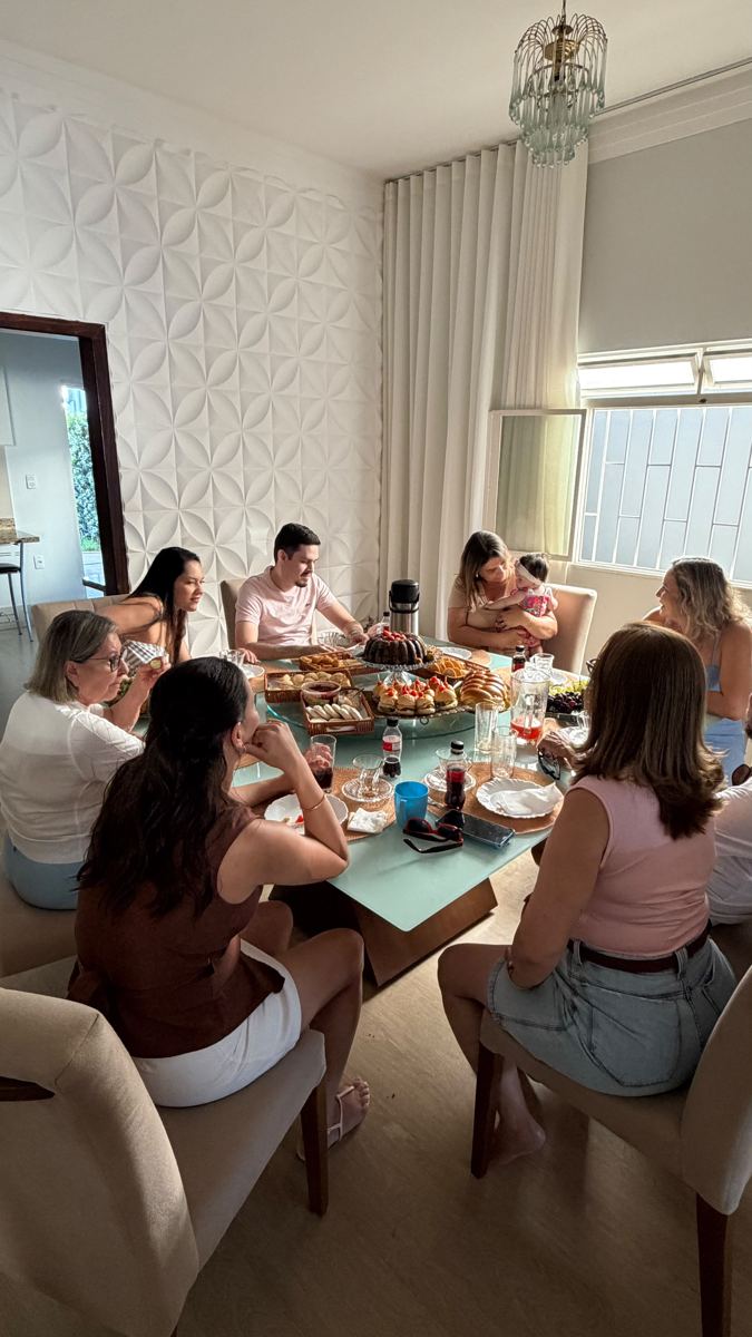 Família reunida em volta de uma mesa com bolo, salgados e frutas da Bolateria