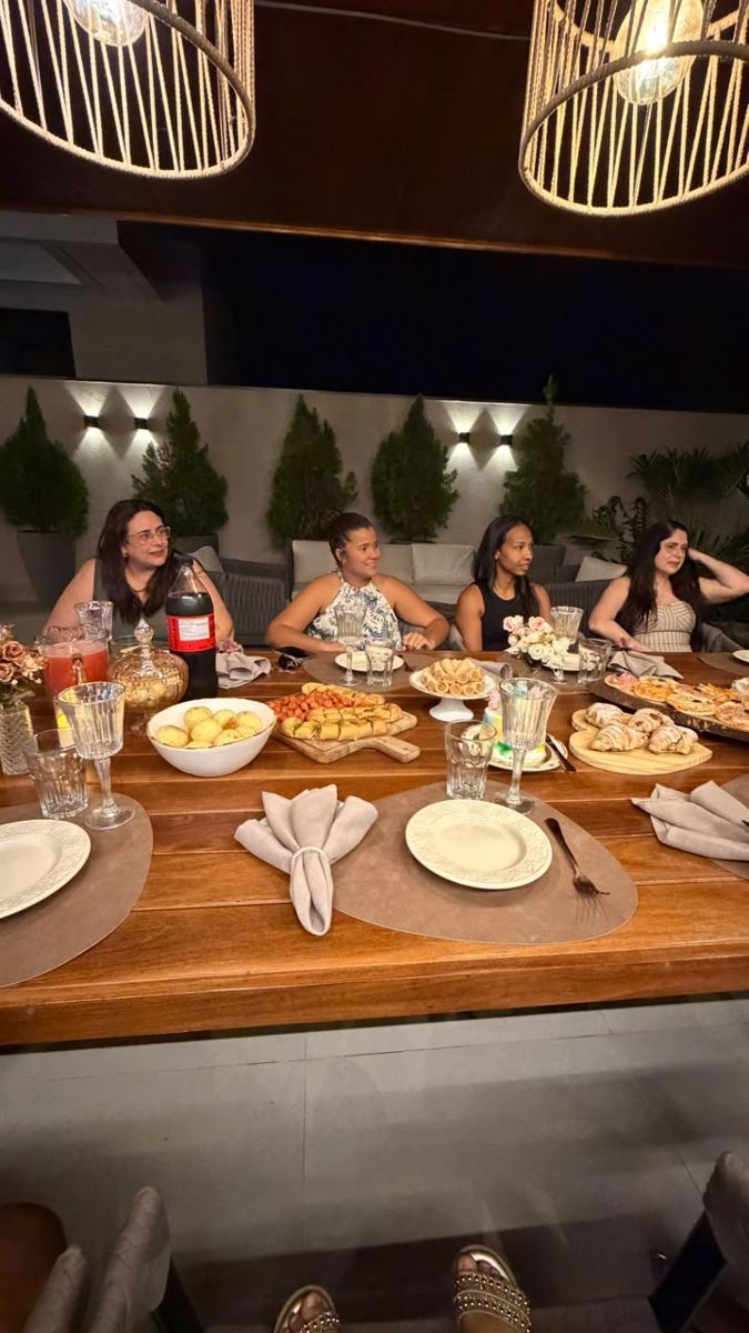 Mulheres reunidas em volta de uma mesa posta pela Bolateria